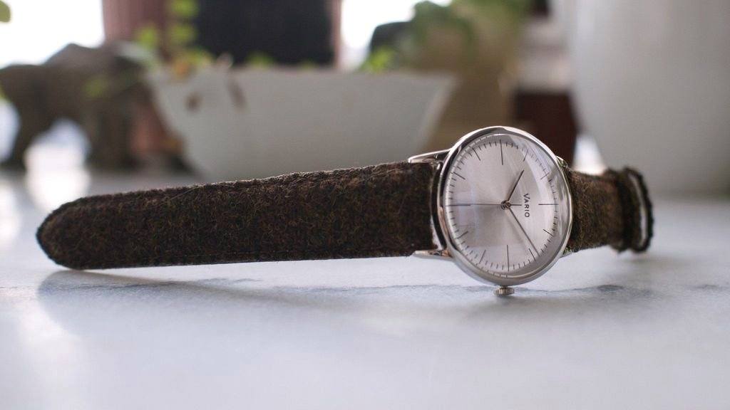 eclipse 38mm silver dress watch with harris tweed strap on table