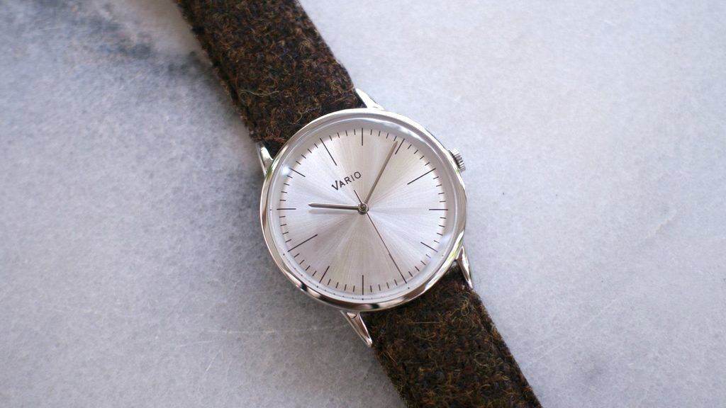 eclipse 38mm silver dress watch with harris tweed strap on table